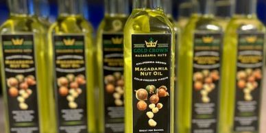 Bottles of Gold Crown macadamia nut oil arranged in rows.