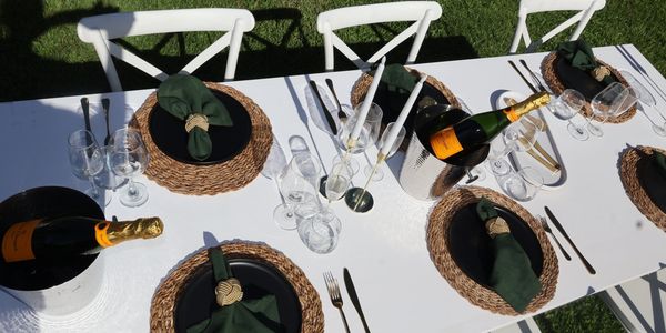 Outdoor table set with champagne and elegant place settings for six.