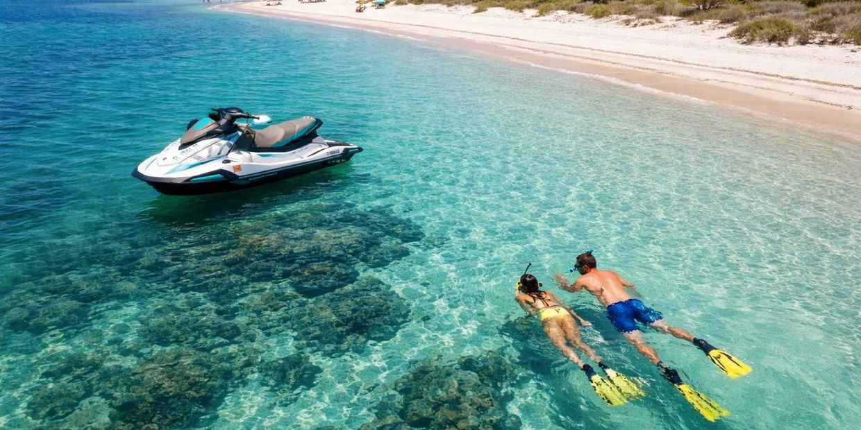 Aerial view of a couple snorkeling in clear turquoise water at Shell Key Preserve with a Yamaha ski.