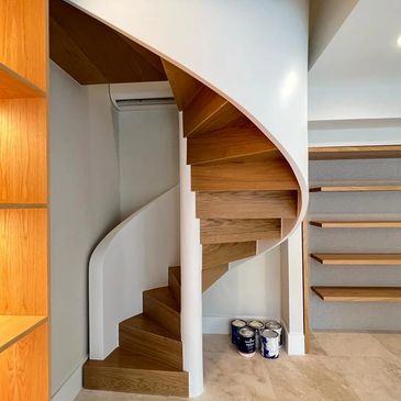 Elegant spiral staircase installation featuring sleek wooden steps.