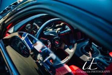 Interior of a sports car with a steering wheel and gear shift.