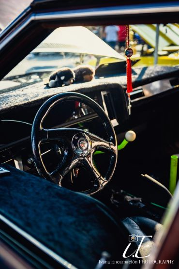 Close-up of a vintage car steering wheel and interior.