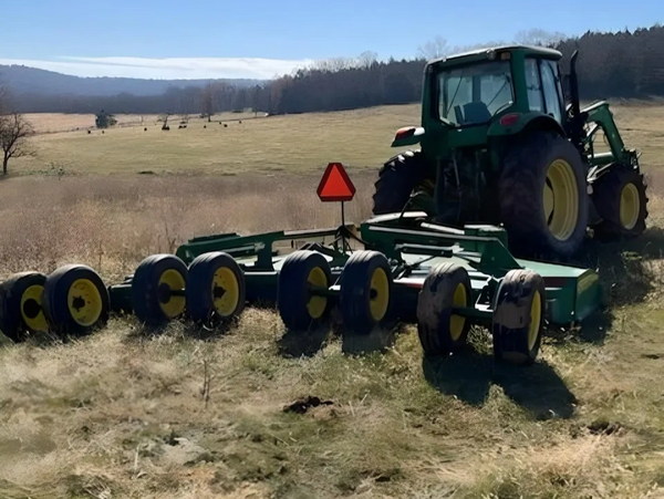 tractor mowing field & preparing land