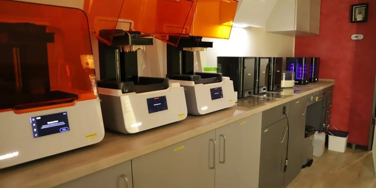 Impresoras 3D industriales en línea dentro de un laboratorio de producción.