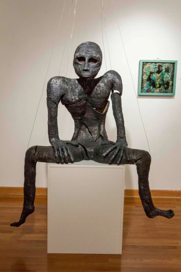 Abstract humanoid sculpture with elongated limbs.