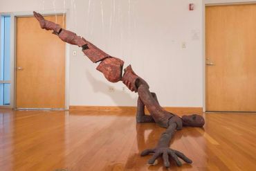 Abstract wooden sculpture mimicking a crawling figure.