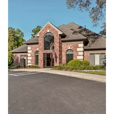 Large brick building with American flag and arched windows.