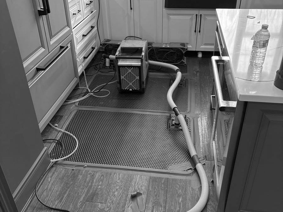 Water extractor set up in the kitchen to remove water in the flooring
