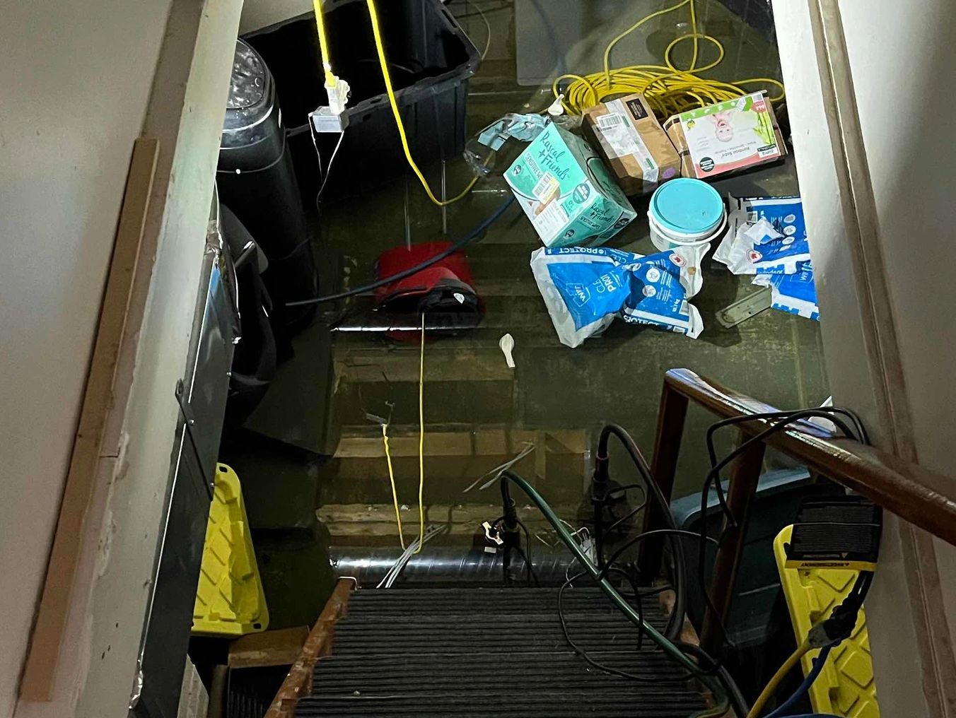 Flooded basement with various items floating.