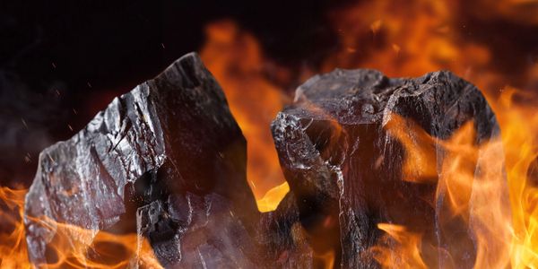 Close-up of burning charcoal with bright orange flames.