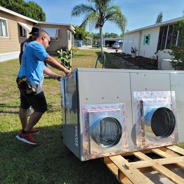 Two men inspecting a large HVAC unit in a residential area.
