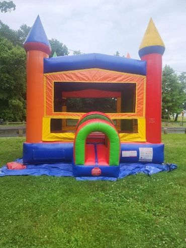 Colorful inflatable bounce house set up on grass outdoors.