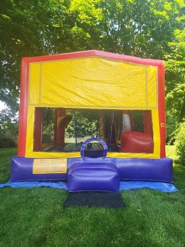 Colorful inflatable bounce house set up on green grass outdoors.