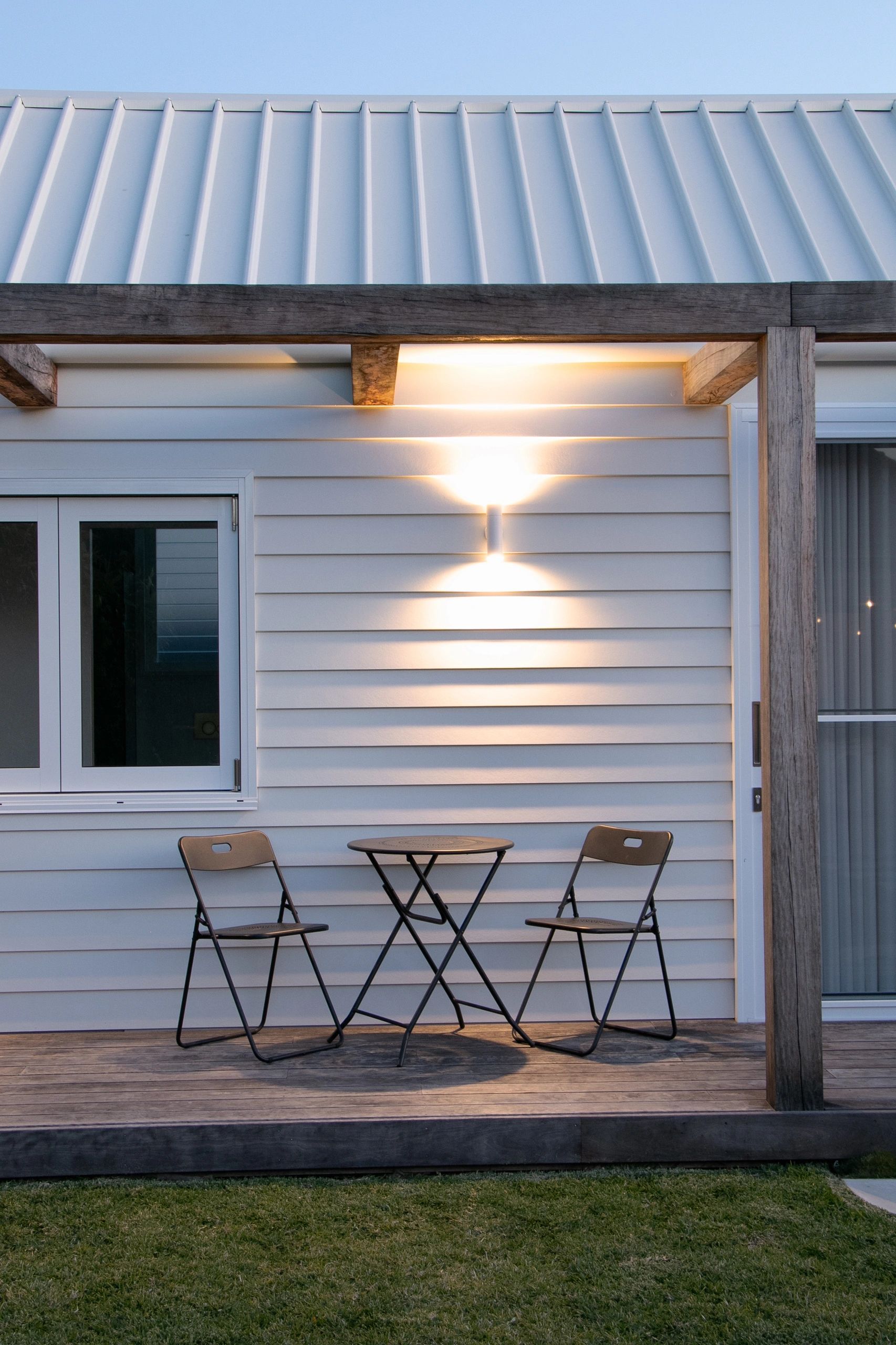 Outdoor patio with two folding chairs and a small round table.