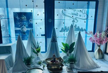 A cozy indoor winter-themed setup with white tents, plants, and a fireplace.