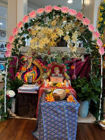 Decorative altar with flowers, lights, and religious symbols.
