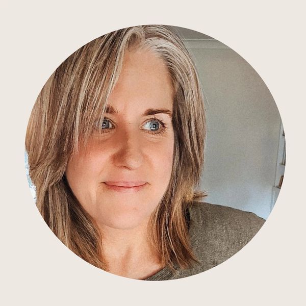 Close-up of a smiling woman with light brown hair and blue eyes.