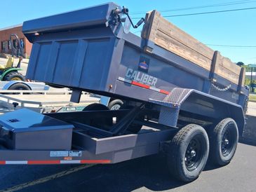 Heavy-duty dump trailer with wooden side extensions.