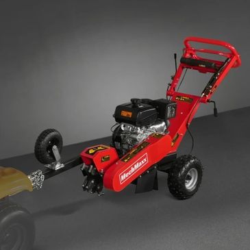Red wheeled motorized garden tiller on gray floor.