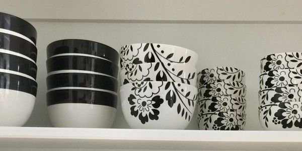 Bowls stacked neatly on cabinet shelf.  Kitchen organizing by Pretty Neat Professional Organizing