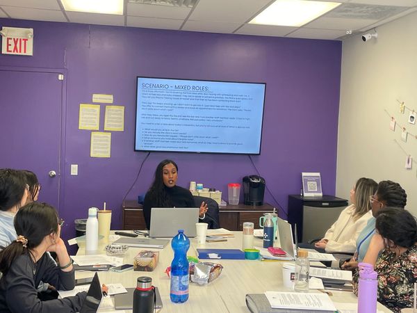 Group attending a presentation in a classroom with purple walls.