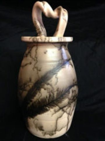 Artistic ceramic vase with a heart-shaped handle and unique black patterns.