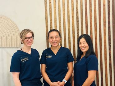 Three estheticians at pemspa skincare & massage in newton smiling in a beautifully decorated room