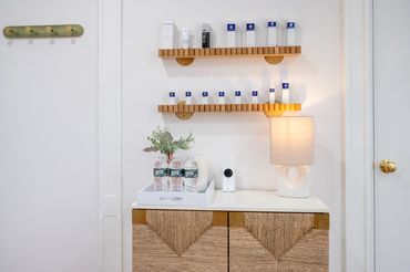 Display wall with organized skincare products, plants, and warm lighting.