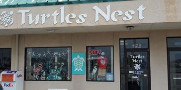 Exterior of Turtles Nest store with signage and window displays.