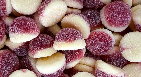 Close-up of sugar-coated red and white gummy candies.