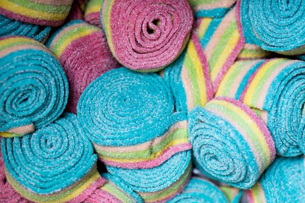 Colorful rolled candy strips covered in sugar.