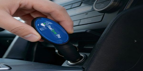 Hand inserting a FuelSync Pro device into a car's power outlet.