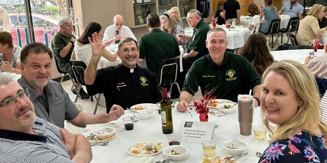 Group enjoying a meal at a Knights of Columbus event with a welcoming atmosphere.
