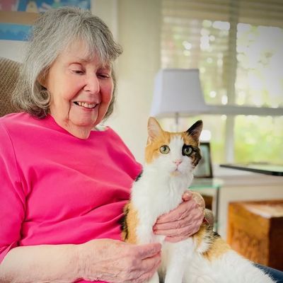 Seaside Senior client holding her pet cat in her lap