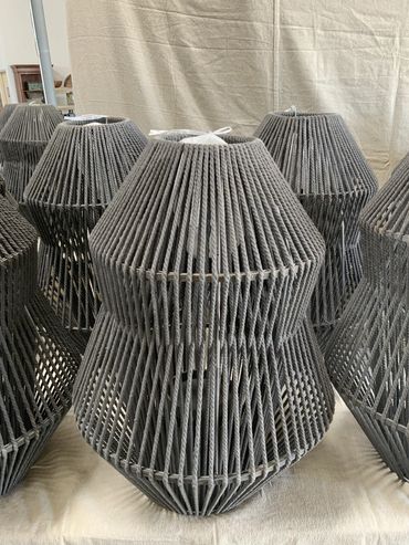 Modern geometric lampshades made of woven gray material.