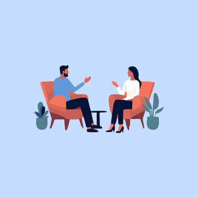 Two people engaged in a conversation while sitting in armchairs.