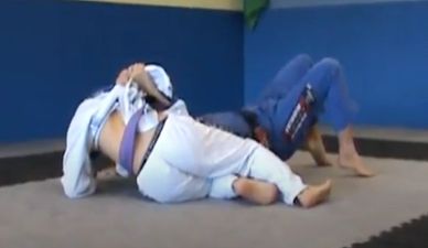 Two martial artists practicing Brazilian Jiu-Jitsu on mats.