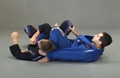 Two martial artists practicing Brazilian jiu-jitsu on a mat.