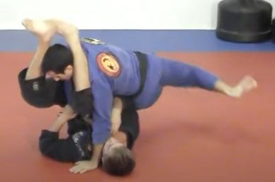 Two people practicing Brazilian Jiu-Jitsu on a mat in a gym.