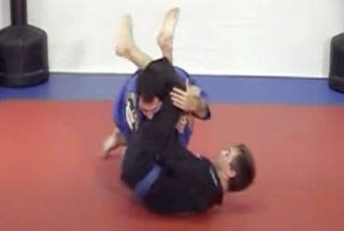 Two martial artists practicing Brazilian Jiu-Jitsu grappling on mats.