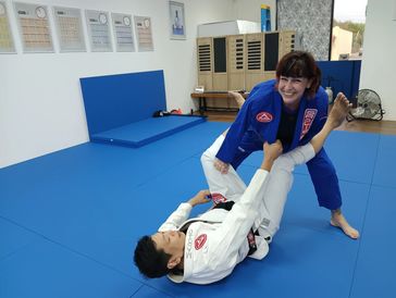 Having fun at GBElmonte Jiu-Jitsu while opening the guard. Training men and women in sports 