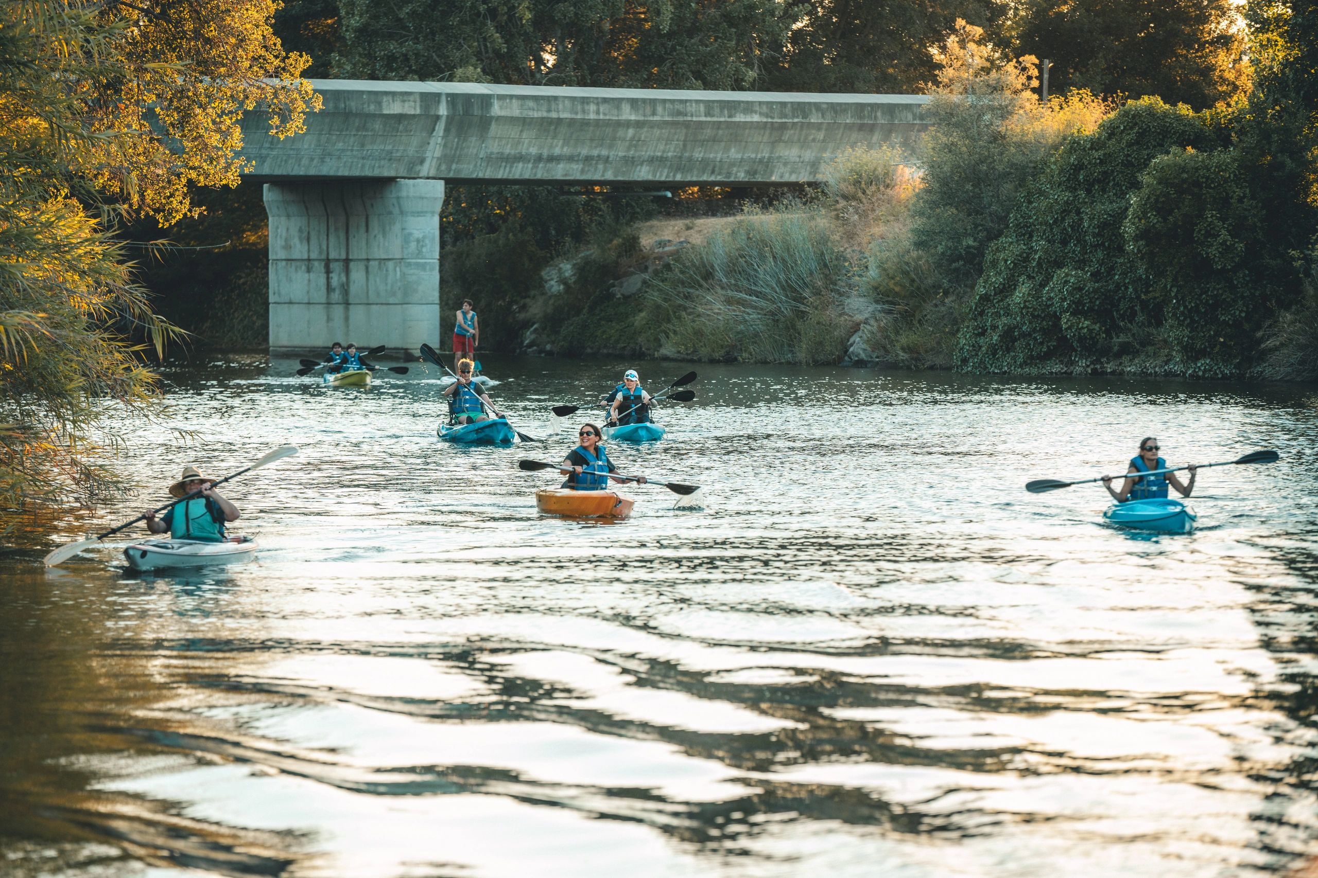 Guided kayak tour on the Napa River in downtown Napa with paddlers passing under a bridge