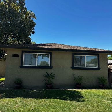 Green colored stucco with dark window frames. 
