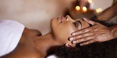 Persona recibiendo masaje facial en ambiente relajante.
