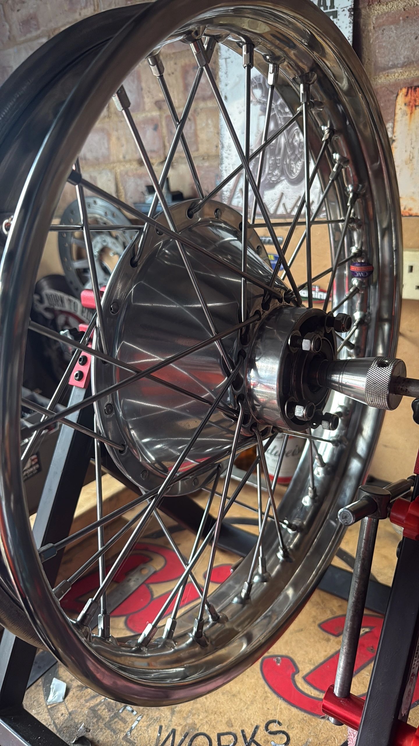 Close-up of a shiny motorcycle wheel with spokes and hub.