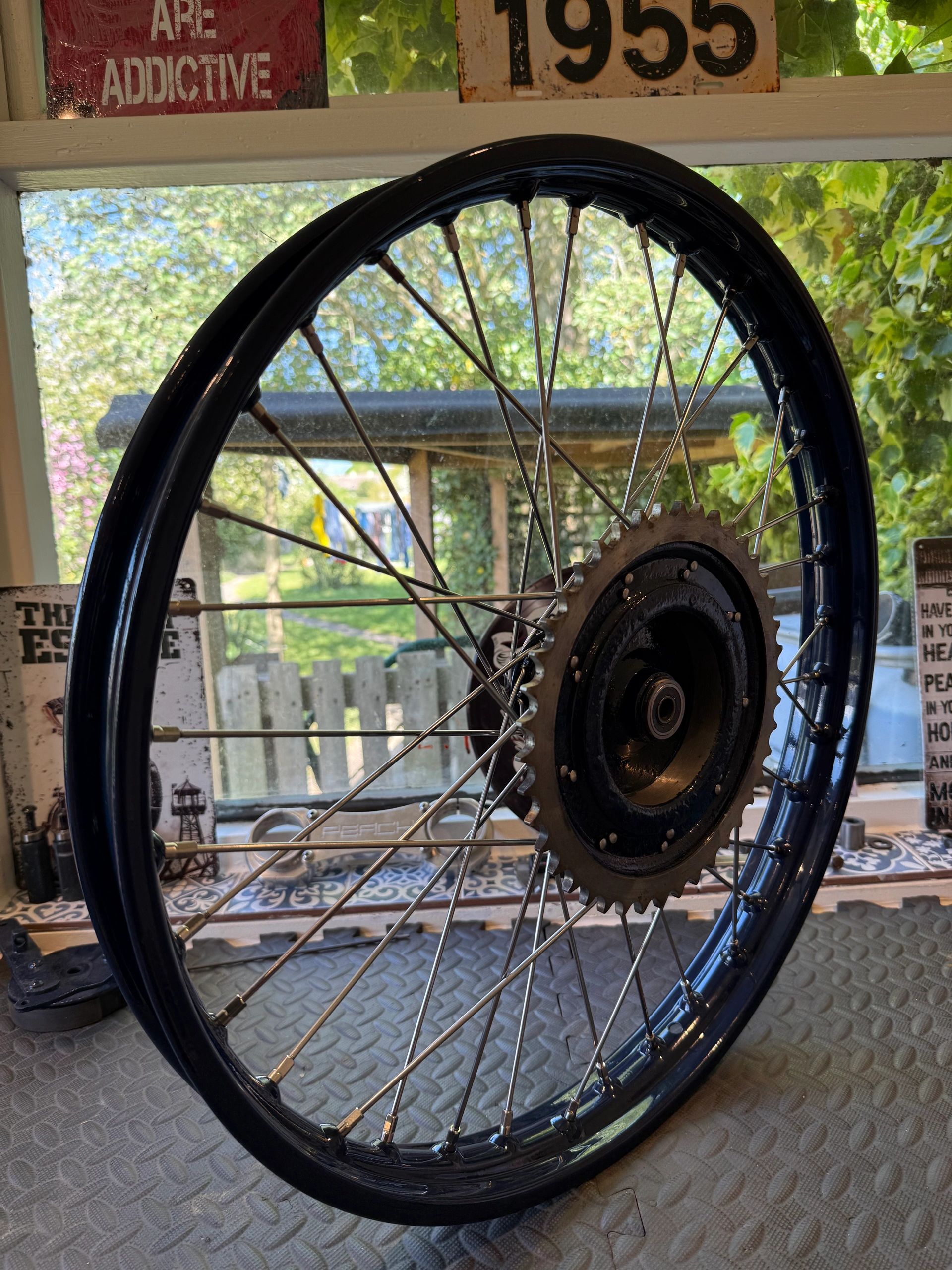 Close-up of a bicycle wheel with a sprocket indoors.