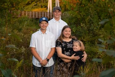 Mother and 3 kids embracing 