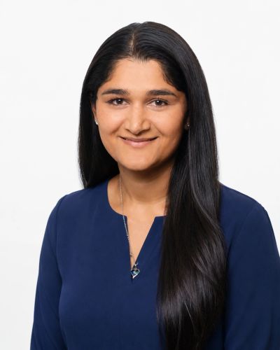 Portrait of a smiling woman with long black hair in a blue top.