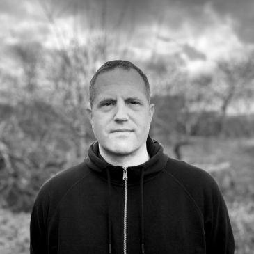 Black and white portrait of a man outdoors.