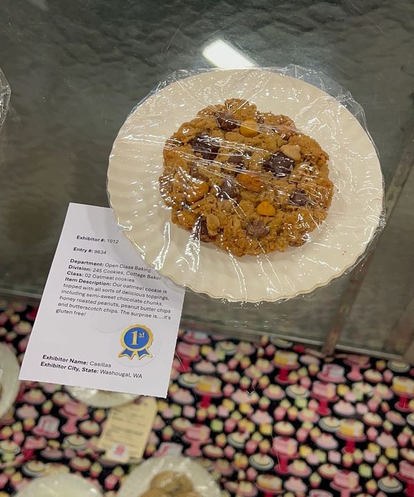Chocolate chip cookie on a plate with a description card.